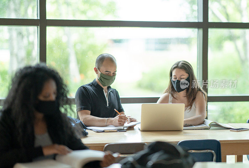 大学生们戴着口罩在讲堂里