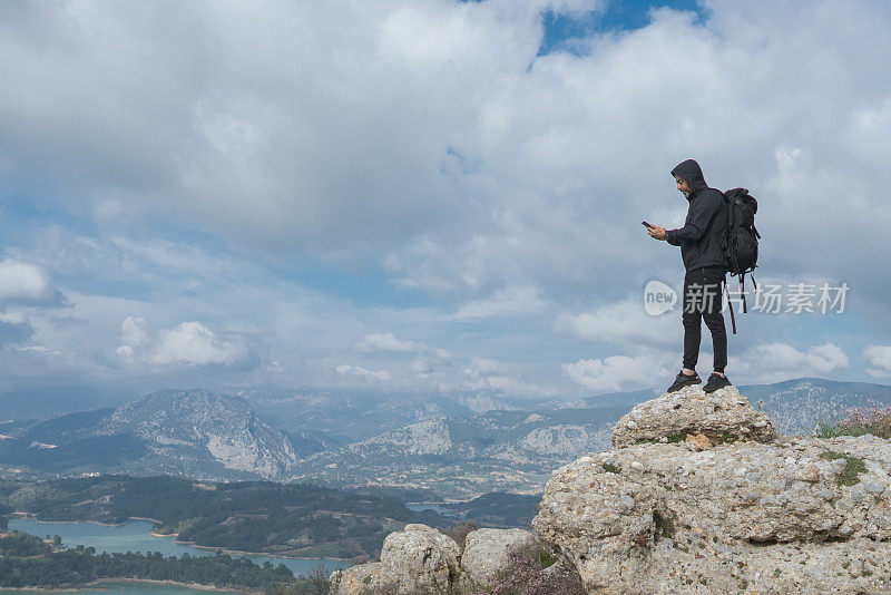 用智能手机登山的人。