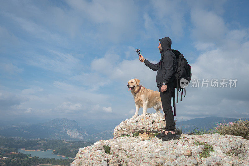 旅行者和他的狗在大自然中用万向节拍摄。