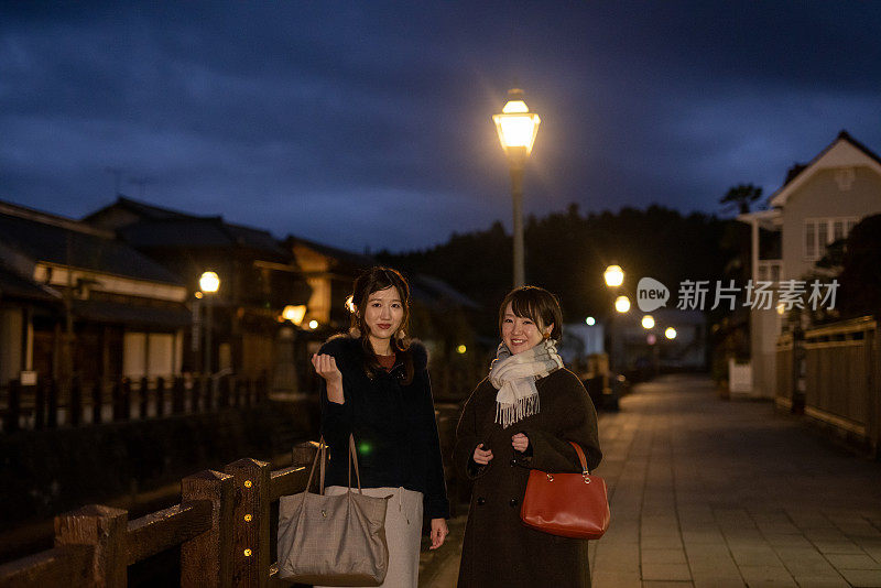 年轻的女性朋友在晚上参观古老的日本村庄