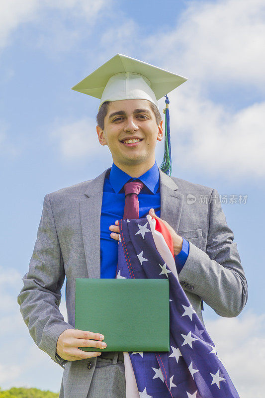 快乐快乐的肖像帅气的拉丁男学生穿着长袍和帽子，出席他的毕业典礼在美国，美国