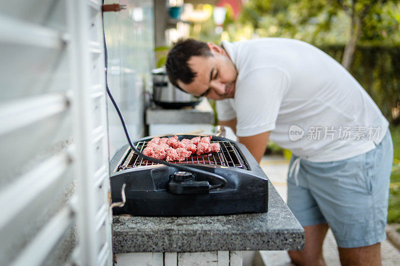 在烧烤上烤肉的男人