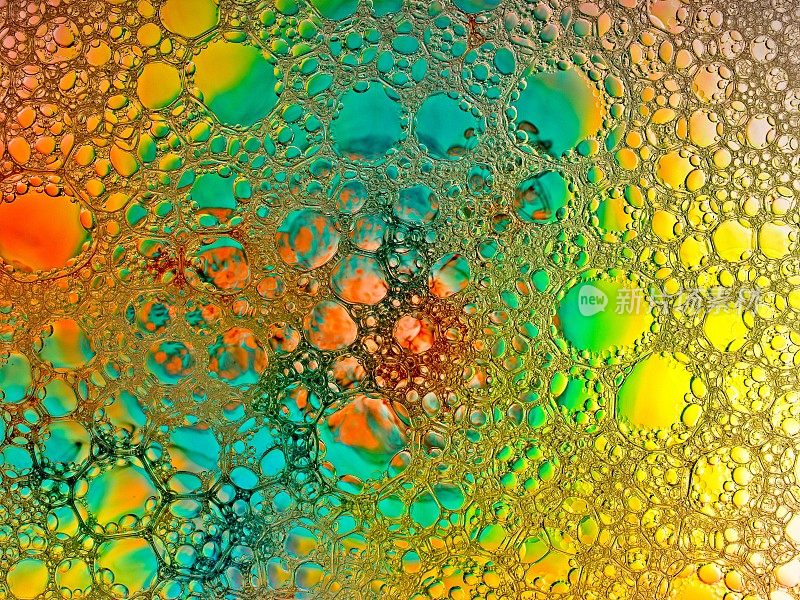 由水、油和肥皂混合而成的棱柱色，充满活力的色彩泡沫抽象