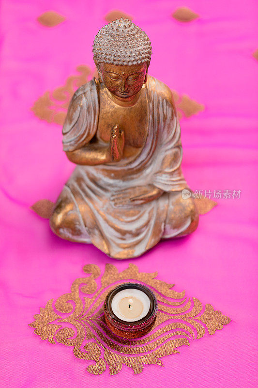 金佛从天而降，在寂静的氛围中，坐在一根粉红色和金色的印度教纱丽绳上