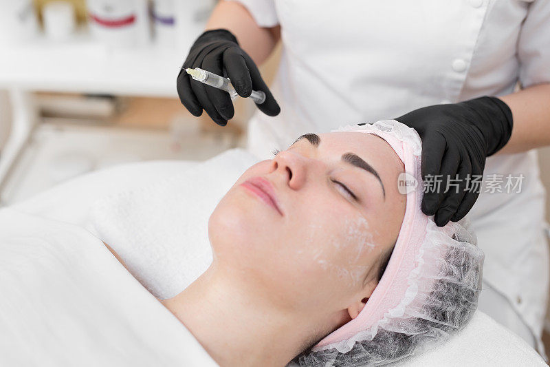 女性面部美容治疗。Biorevitalization皮肤治疗。在医疗沙龙注射。用透明质酸制剂在眼区进行生物活性恢复的程序