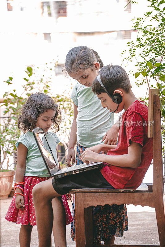 可爱的印度男孩和女孩在家里与在线教师在线学习