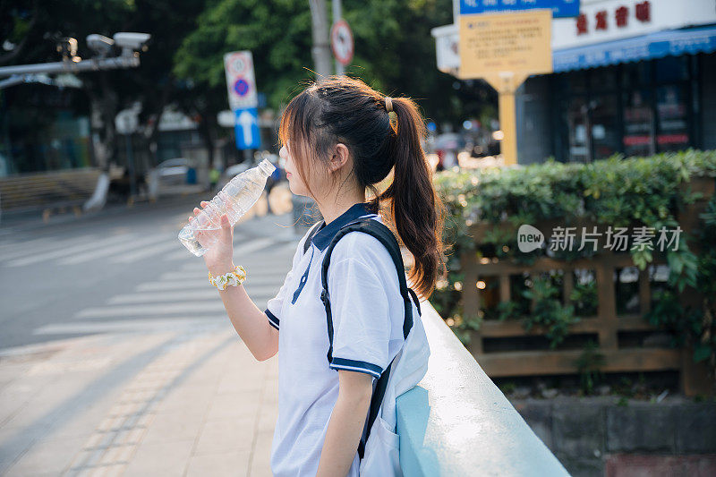 亚洲女孩在阳光下畅饮