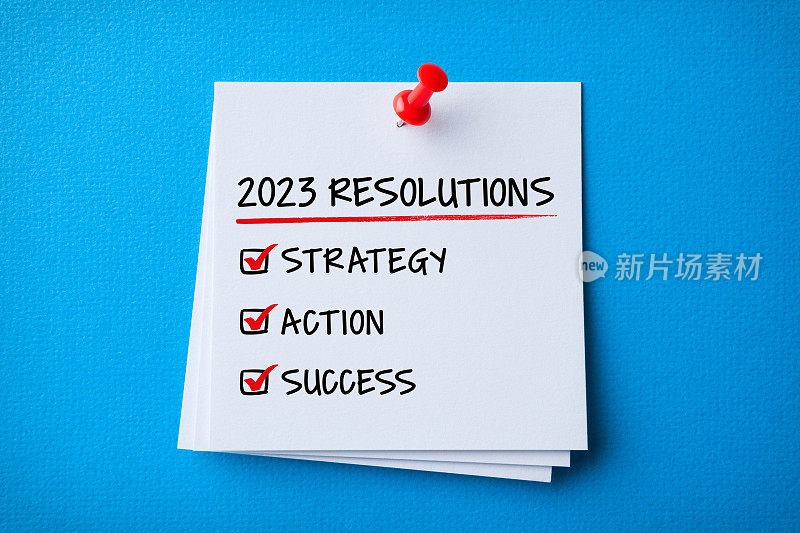 白色便签与2023年新年决心和红色推针在蓝色纸板背景
