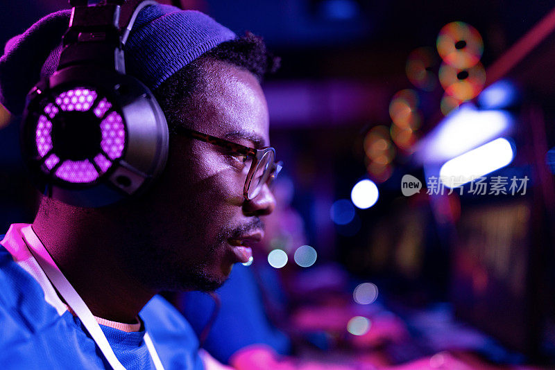年轻的非裔美国玩家戴着耳机。