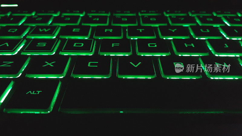 带绿色指示灯的Qwerty型笔记本电脑键盘。现代科技背景