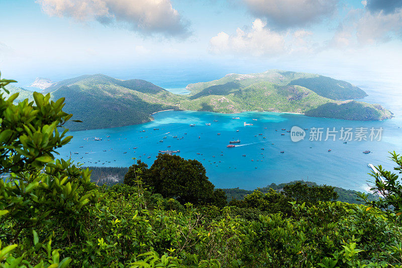 越南孔岛本丹港，湛蓝的大海，蓝天山和五颜六色的船只。