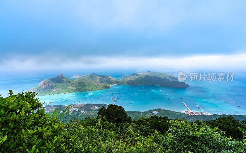 越南孔岛本丹港，湛蓝的大海，蓝天山和五颜六色的船只。