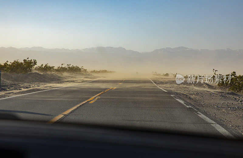 空旷的沙漠道路与地平线上的沙尘暴-死亡谷，加利福尼亚