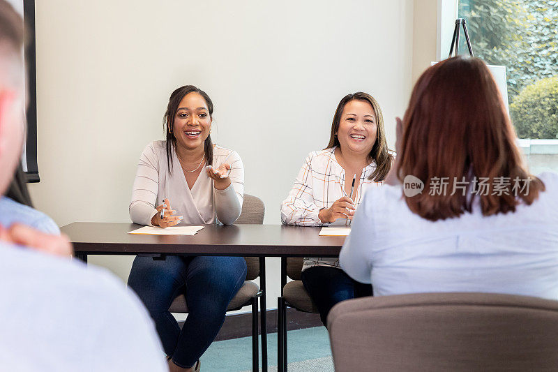 两名妇女是正在举行社区市政厅会议的房间里的主要人物