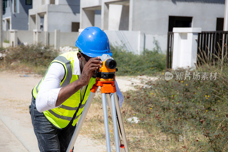 测量员在建筑工地使用经纬仪，工程师测量土地和检查道路，一个人，工业概念。