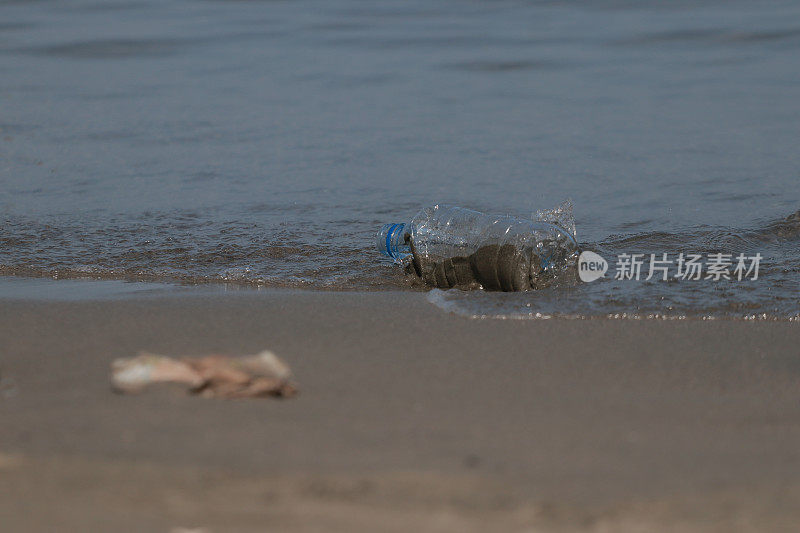 塑料垃圾和瓶子散落在海滩上