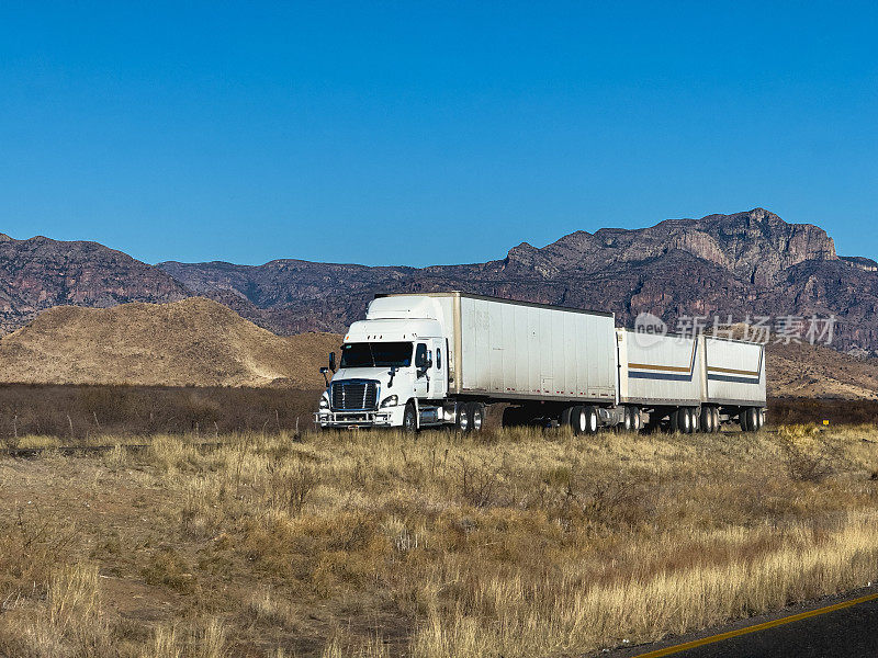 白色半卡车侧视图赛车在墨西哥奇瓦瓦州的高速公路在一个阳光明媚的日子