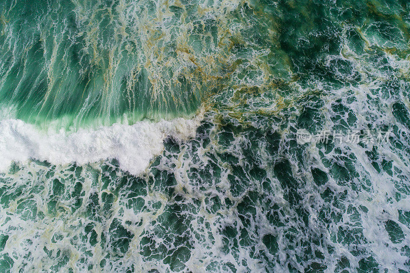 海浪在海里溅起水花的鸟瞰图。