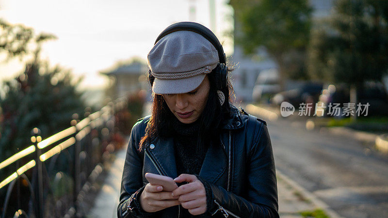 一个女人在街上用手机听音乐