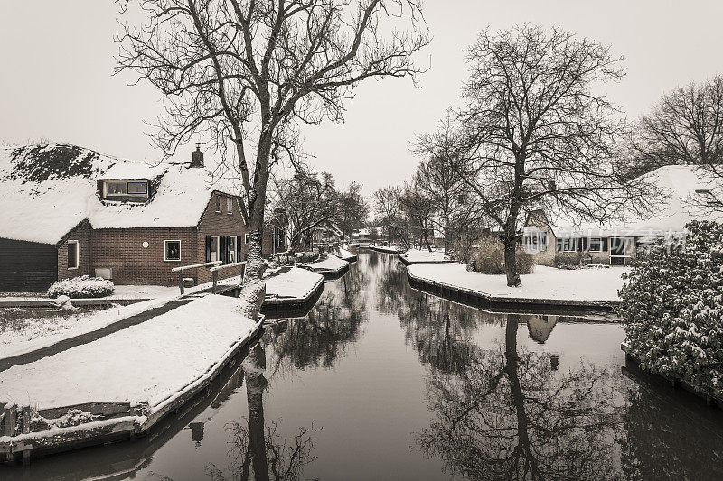 在一个寒冷但美丽而平静的冬天，Giethoorn村附近的Dwarsgracht有积雪的运河