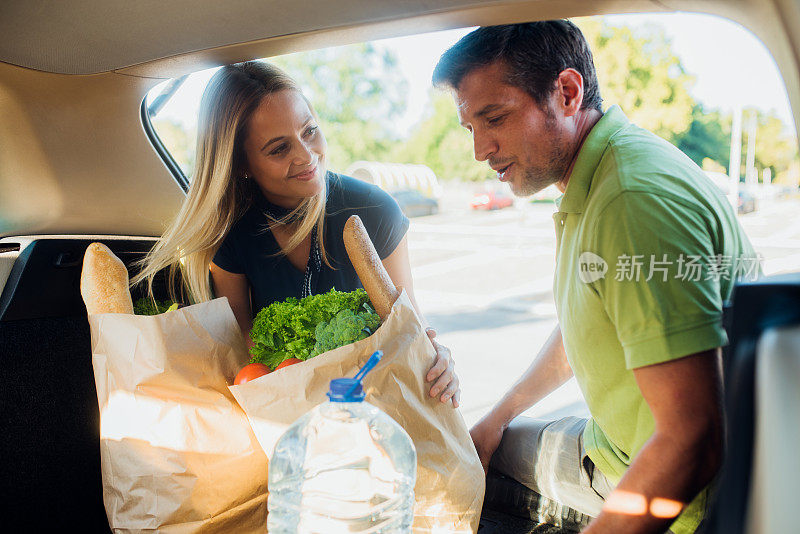 一对幸福的夫妇在车里打包食品