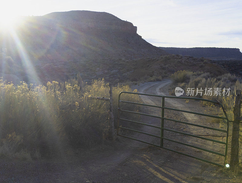 午后的阳光照耀着台地和乡村农场大门，通往牧场和牧场的维珍河附近的罗克维尔犹他州