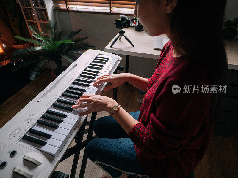 独自在家键盘钢琴爱好年轻女子用智能手机练习钢琴