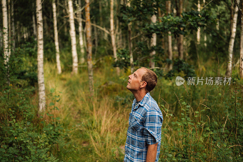 英俊的真正的男人户外在森林森林在夏天