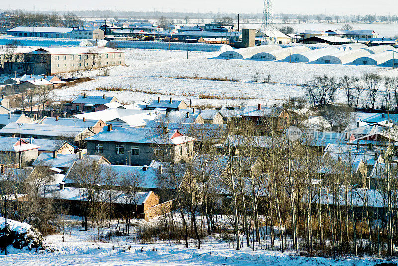 冬天，雪覆盖着房子和田野