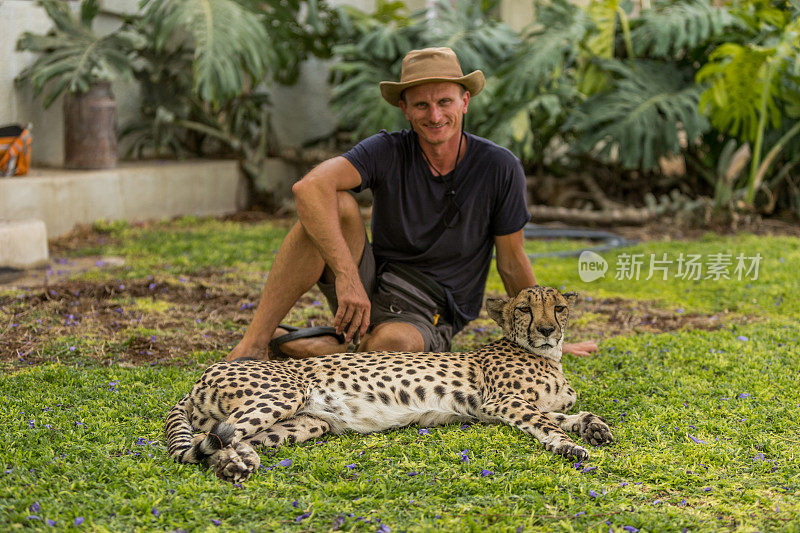 成熟的男人和猎豹坐在一起