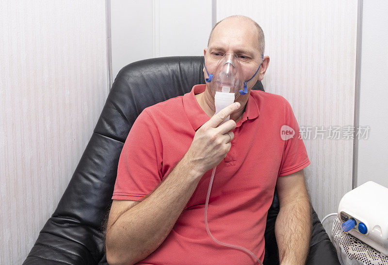 一个40到50岁的白人男性，用喷雾器吸入。