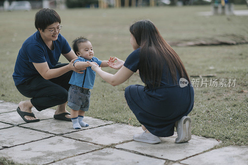 亚洲华人家庭教小男孩在公园迈出第一步