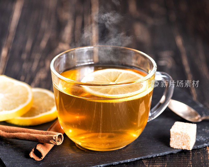 深色木桌上放着一杯热柠檬姜茶。