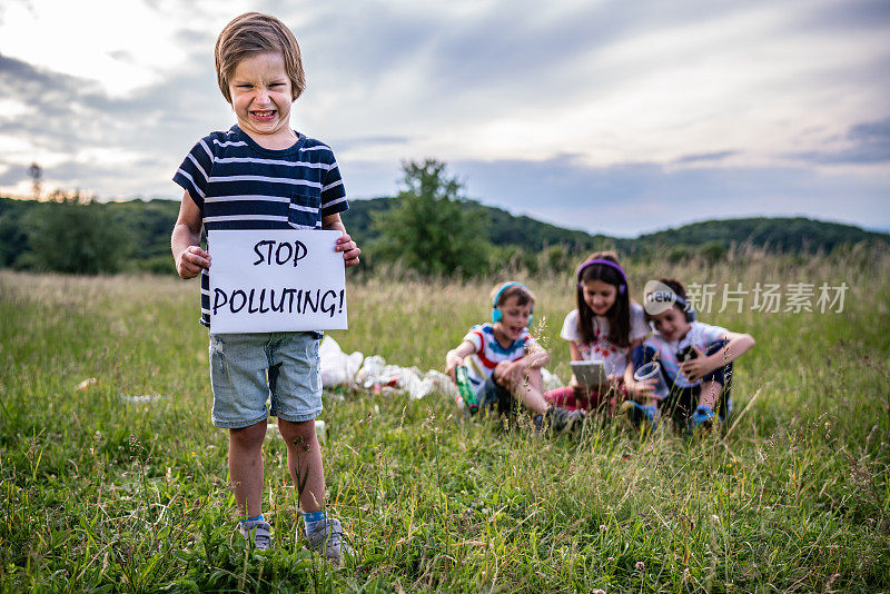 小男孩手持标语“停止污染”