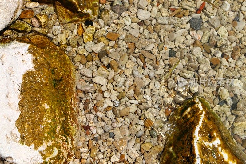 埃吉尔迪尔湖岸边的彩色小石头和长满苔藓的大石头