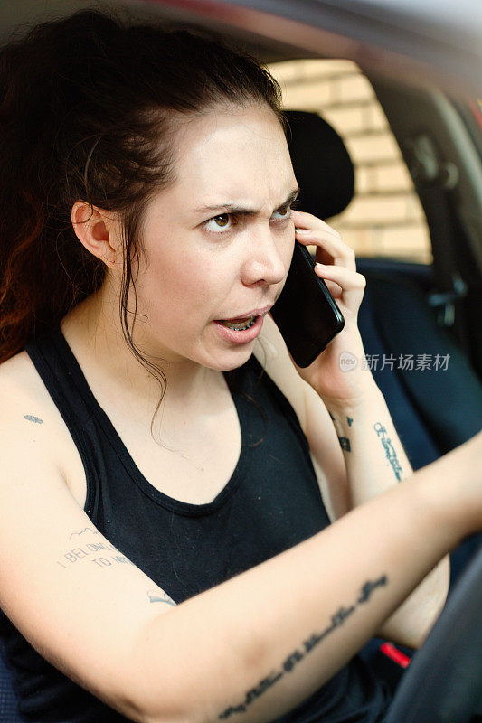 黑发的年轻女子正在用手机进行一场愤怒而艰难的谈话