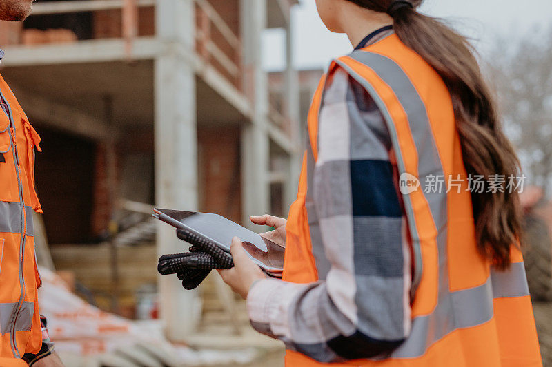 两名建筑师在建筑工地使用数字平板电脑