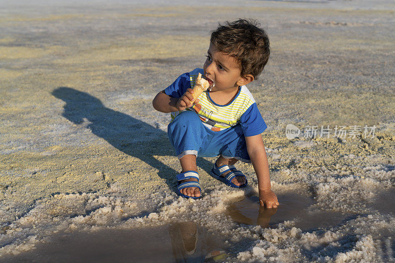 小男孩在安卡拉盐湖玩盐水和吃冰淇淋