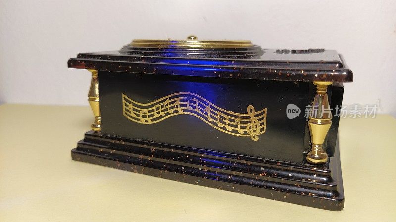 老式的黑色音乐盒。这些钞票被涂在棺材的正面。高音谱号在右边。摆在桌面上的项目