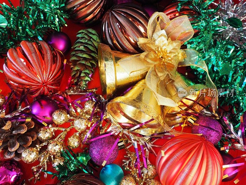 圣诞背景与圣诞装饰，节日球，铃铛，蝴蝶结，冷杉锥，圣诞树雨。新年快乐，圣诞快乐。红色，棕色，条纹，绿色，金色，紫色，五颜六色的装饰
