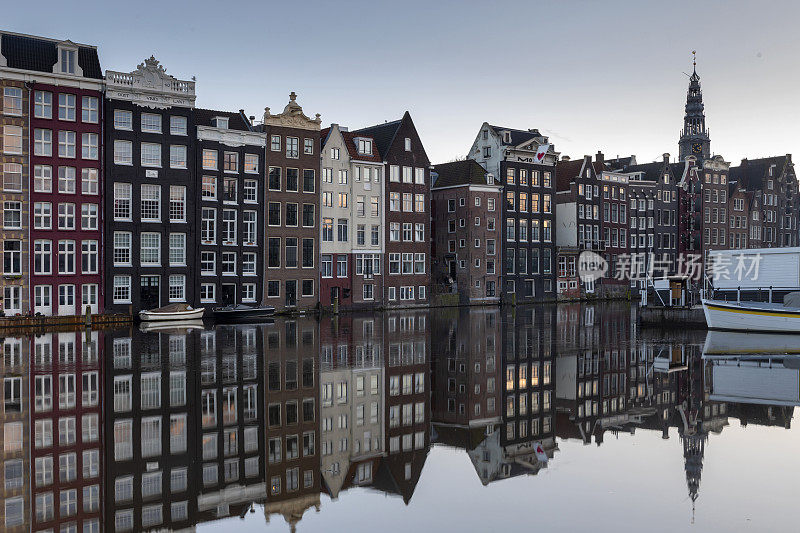 观光船和运河房屋在Damrak在阿姆斯特丹市中心