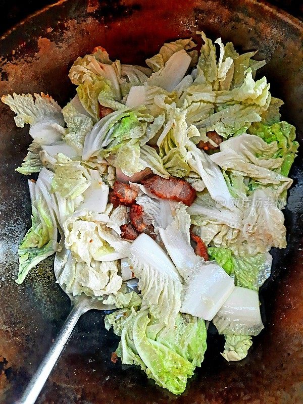 用平底锅煸炒五花肉白菜。