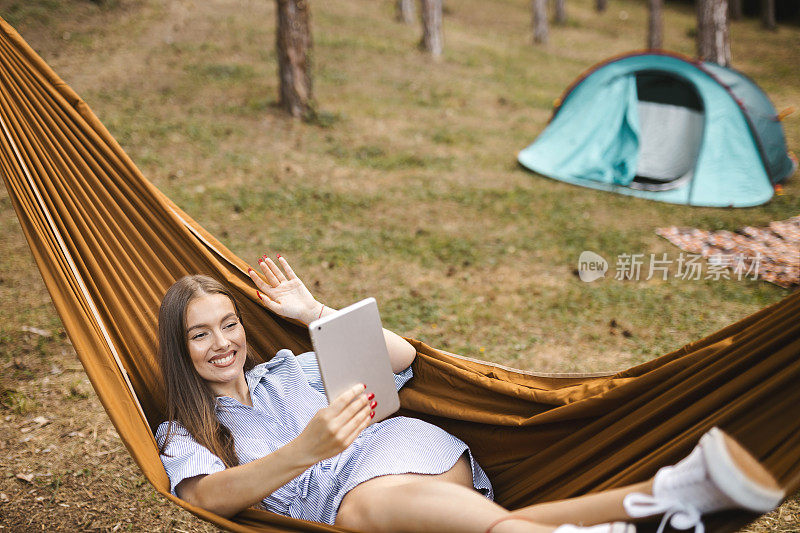 一名女子在森林里休息和露营时使用数码平板电脑