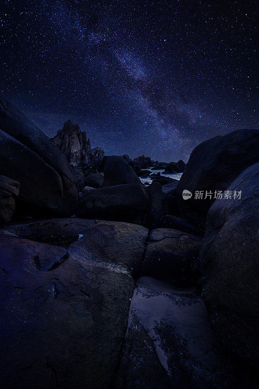 繁星满天，银河环绕海岸，巨石环绕