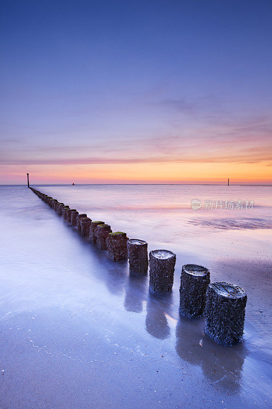 日落时分，荷兰泽兰海滩上的防波堤
