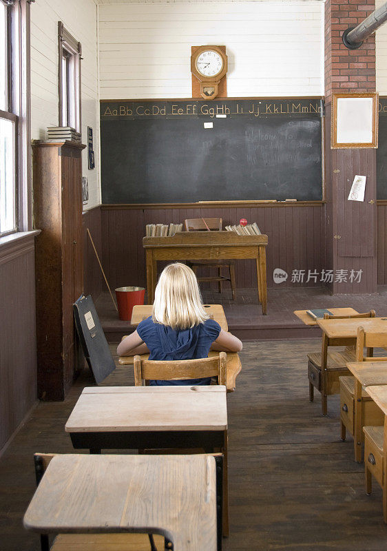女孩坐在一间古老的校舍里