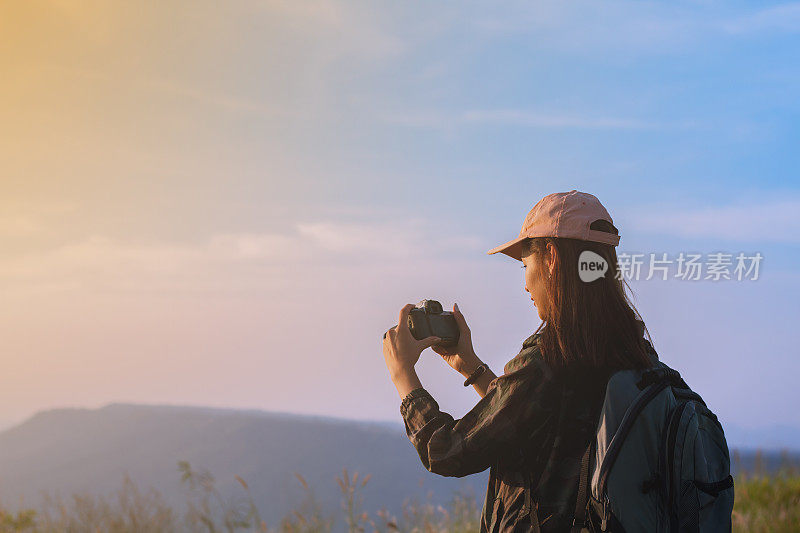 女性亚洲与背包拍照在日出的海边山峰
