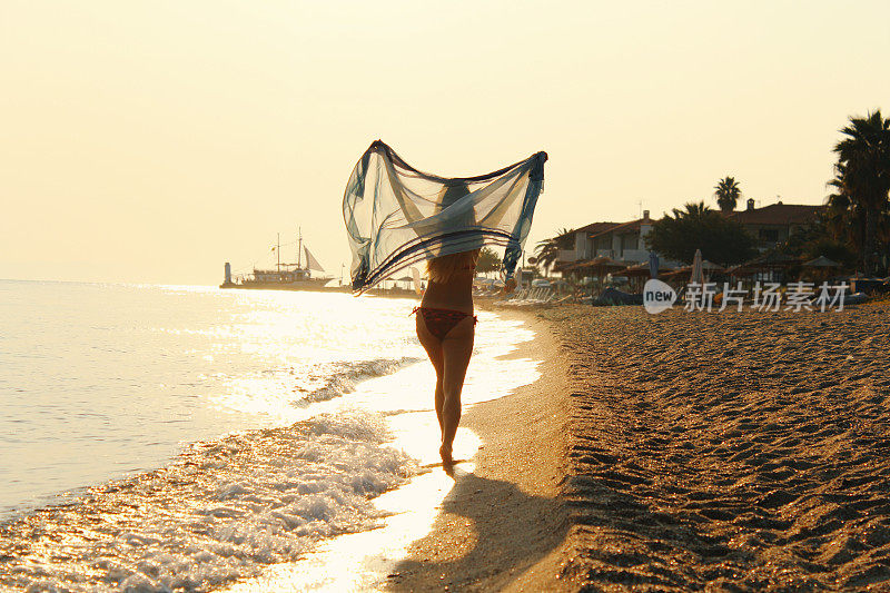 快乐美丽的女人女孩在日出的海滩上跑步