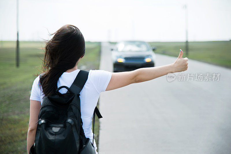 女人竖起大拇指让她搭车