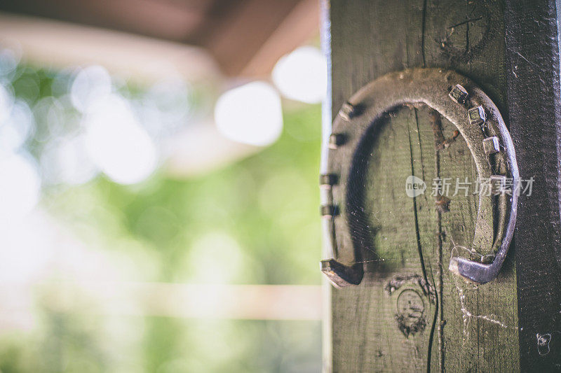 旧生锈的马蹄铁挂在木头背景上。